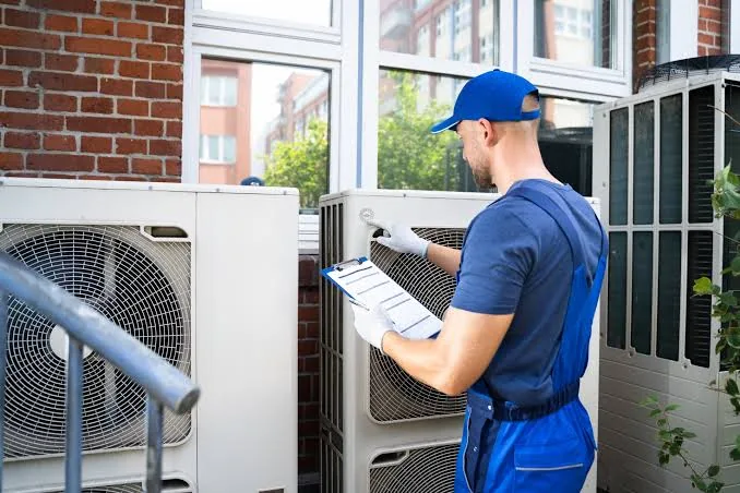 Representative image of residential outdoor heat pump equipment being checked